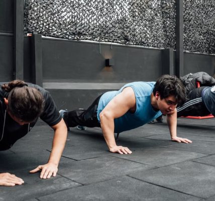 Men performing push-ups during a group workout session in Mexico City gym.